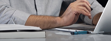 A close-up on a laptop with Kingston IronKey USB drive plugged in and a man’s hand typing on the keyboard