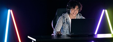 a young gamer playing on his laptop in a dark room