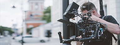 Professional videographer filming a movie in the street